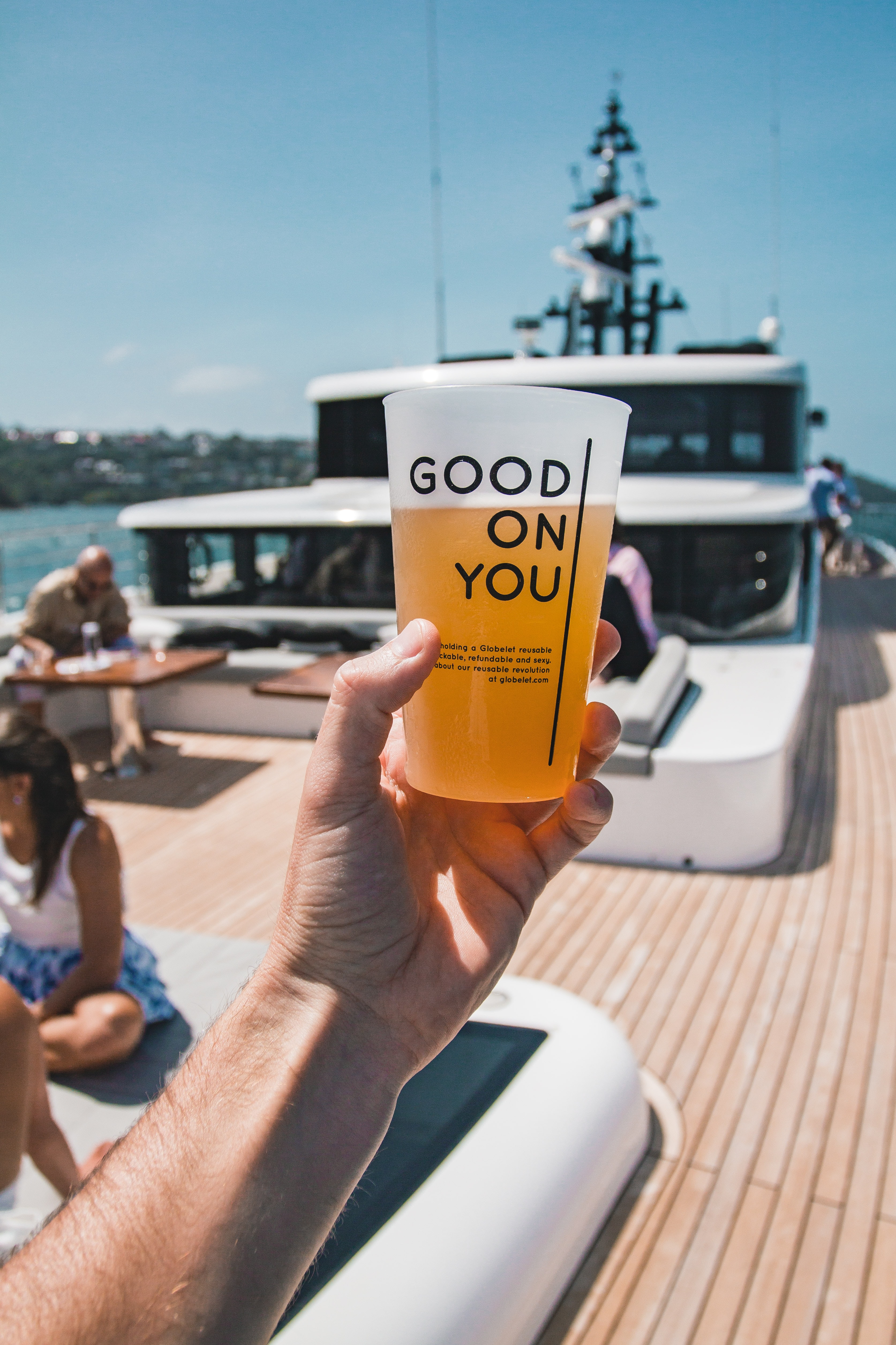 Une femme sur un bateau qui tient un verre de bière.